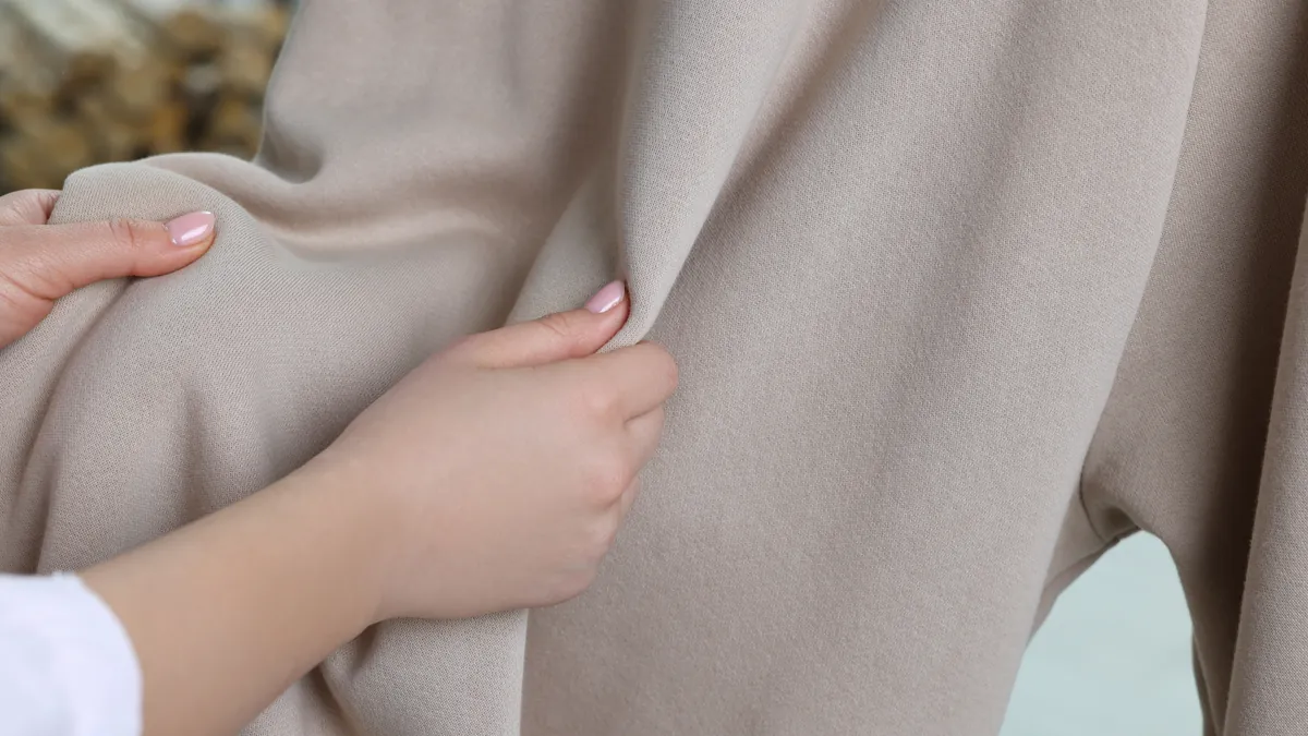 Hands touching the texture of a fabric in a store, touch as part of the buying decision
